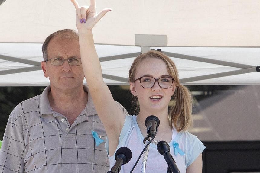 Cassidy Stay stands with her grandfather Roger Lyon (left) as she addresses the crowd during a memorial service for members of the Stay family who were murdered in their home Wednesday, in Spring, Texas on July 12, 2014. -- PHOTO: REUTERS