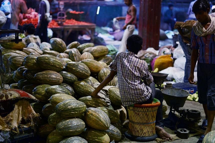 In this photograph taken on July 4, 2014, an Indian child waits for customers at his stall in a vegetable market in New Delhi. -- PHOTO: AFP&nbsp;