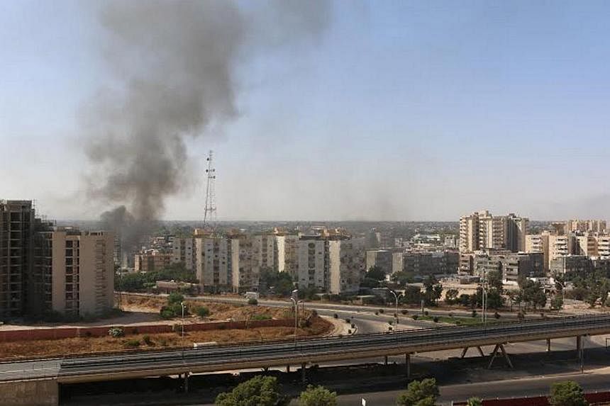 Smoke rises near buildings after heavy fighting between rival militias broke out near the airport in Tripoli July 13, 2014.&nbsp;Deadly clashes raged on Sunday around Libya's main international airport, closing it down, as the anti-Islamist militia t