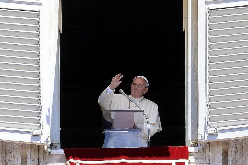 Pope Francis waves as he addresses his Sunday Angelus from the window of his study overlooking St.Peter's Square at the Vatican on July 6, 2014.&nbsp;Pope Francis promised "solutions" to the issue of priestly celibacy in an interview on Sunday that r