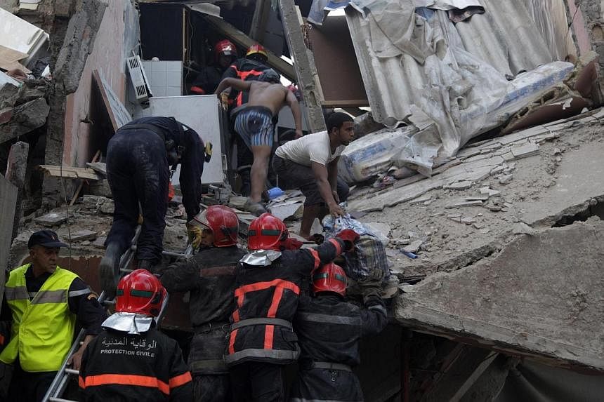 Firefighters search for victims under the rubble after buildings collapsed in downtown Casablanca on July 11, 2014.&nbsp;The death toll after three buildings collapsed in Morocco's largest city and commercial capital Casablanca rose to 23 on Sunday, 