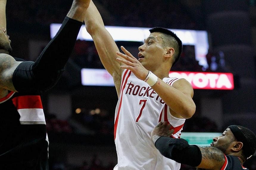 Jeremy Lin of the Houston Rockets drives against Mo Williams of the Portland Trail Blazers and LaMarcus Aldridge in Game One of the Western Conference Quarterfinals during the 2014 NBA Playoffs at the Toyota Center on April 20, 2014 in Houston, Texas