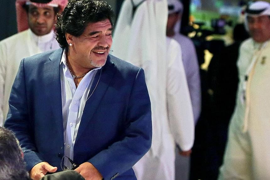 Argentinian football icon and former player Diego Maradona (front left) smiles before attending a panel discussion during the first session of the International Sports Conference in Dubai on Dec 28, 2012. -- PHOTO: AFP