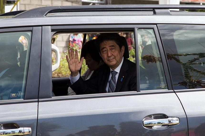 Japan's Prime Minister Shinzo Abe waves to the local during a visit to Wewak in Papua New Guinea on July 11, 2014.&nbsp;Japanese Prime Minister Shinzo Abe said on Monday that he wants to hold a summit meeting with China at the Apec regional leaders m