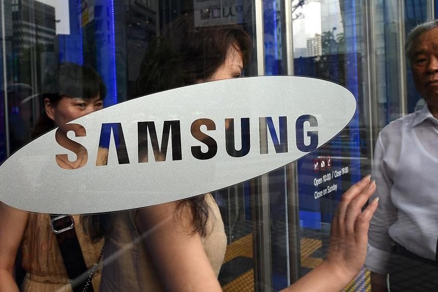 Visitors walk past a glass door showing the logo of Samsung Electronics at the company's showroom in Seoul on July 8, 2014.&nbsp;Samsung Electronics Co Ltd said on Monday that it has temporarily halted business with a Chinese supplier after finding e