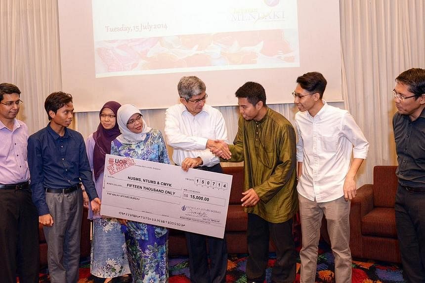 Dr Yaacob Ibrahim (centre, in white) the Minister-in-charge of Muslim Affairs, presenting a cheque for $15,000 to NTUMS president Khairul Anwar Ahmad Basha. Together with them are (from left) PAP MP Muhammad Faishal Ibrahim, NUSMS president Muhammad 