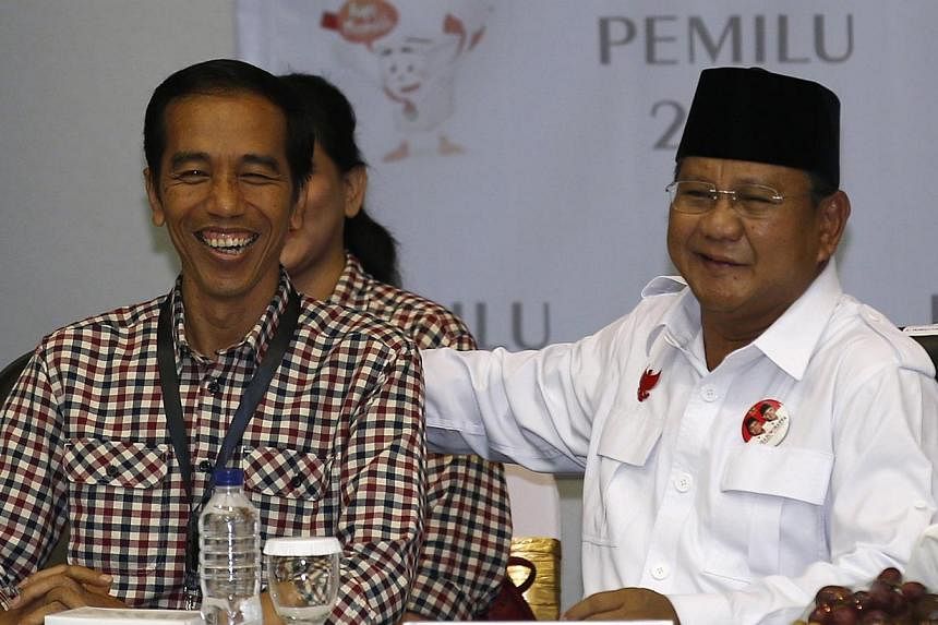 Indonesian presidential candidates Prabowo Subianto (right) and Joko "Jokowi" Widodo attending a ceremony to draw ballot numbers at the Election Commission in Jakarta on June 1, 2014. -- PHOTO: REUTERS
