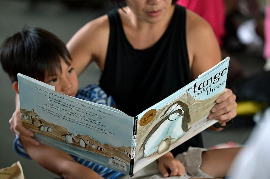 Ms Shi Xiao Wei, 40, with her son at a &nbsp;reading session of children's books organised by local writer Jolene Tan outside the National Library as a response to the NLB's removal of the books And Tango Makes Three and The White Swan Express. -- PH