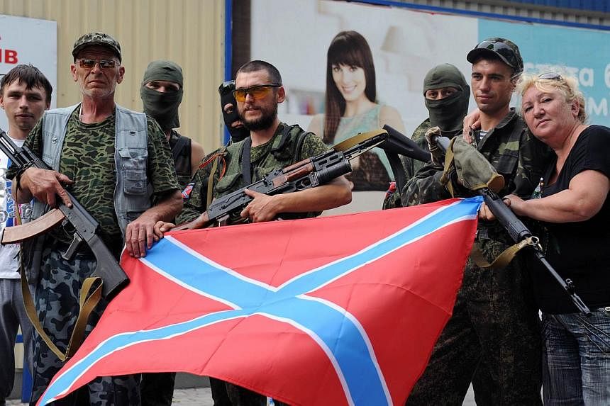 Pro-Russian militants posing with the new Russia flag in Donetsk, eastern Ukraine, on July 13, 2014. -- PHOTO: AFP