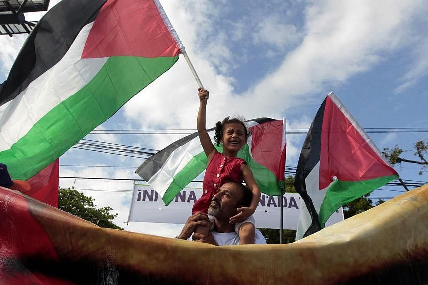 A girl holds a Palestinian flag during a march in Managua against Israel's military action in Gaza July 14, 2014. -- PHOTO: REUTERS