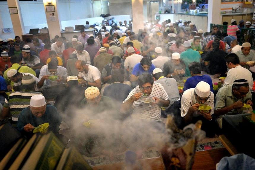 A group of men breaking fast together at Khalid Mosque in Joo Chiat Road in July 2014. -- PHOTO: THE NEW PAPER FILE