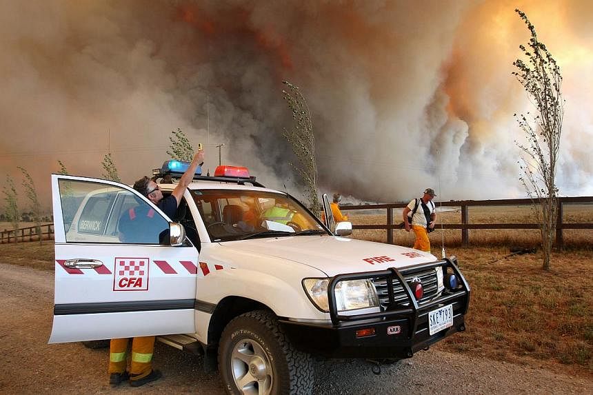 A file photo taken on Feb 7, 2009, shows a Country Fire Authority (CFA) staff member monitoring a giant fire raging in the Bunyip State Park near Labertouche, some 125 kilometres west of Melbourne. -- PHOTO: AFP