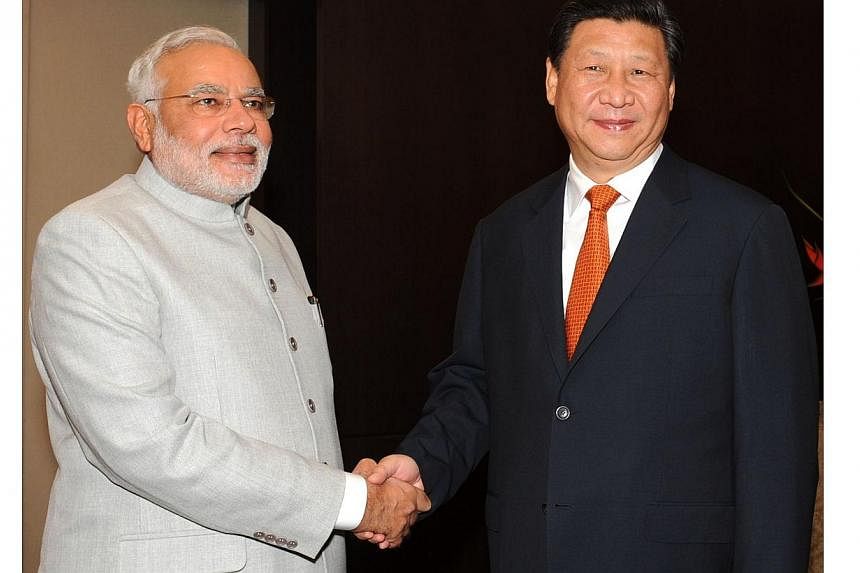 In this photograph received from the Press Information Bureau (PIB) and taken on July 14, 2014, Indian Prime Minister Narendra Modi (left) shakes hands with Chinese President Xi Jinping during the sixth BRICS summit in the Brazilian city of Fortaleza