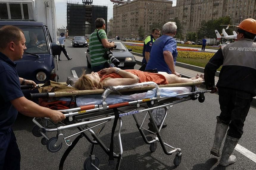 Members of the emergency services move an injured passenger outside a metro station following an accident on the subway in Moscow on July 15, 2014. Twelve people were killed on Tuesday and up to 120 injured when a Moscow underground train derailed be