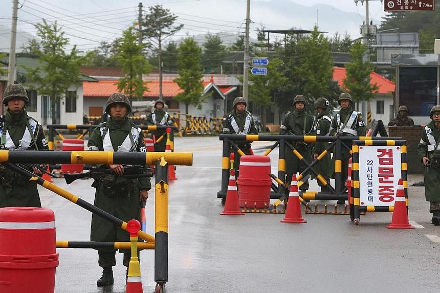 South Korean soldiers stand guard at a temporary checkpoint during a search for the South Korean conscript soldier who was on the run after a shooting incident, in Goseong on June 22, 2014.&nbsp;A military police investigation into the deadly shootin
