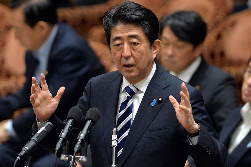 Japanese Prime Minister Shinzo Abe answers a question of an opposition lawmaker at the Lower House's budget committee session at the National Diet in Tokyo on July 14, 2014. The Japanese government's current interpretation of the Constitution limits 