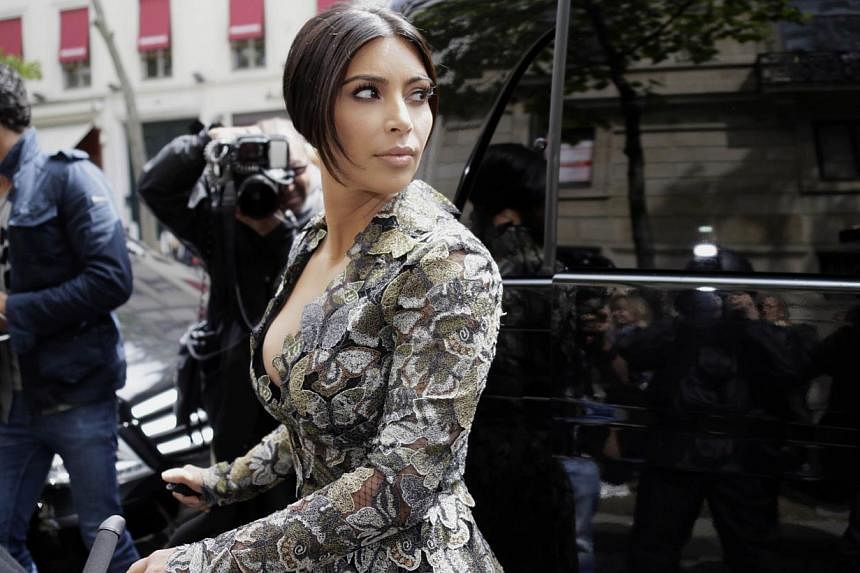 Kim Kardashian stands in front of a vehicule with a stroller as she leaves her hotel on May 23, 2014 in Paris. -- PHOTO: AFP
