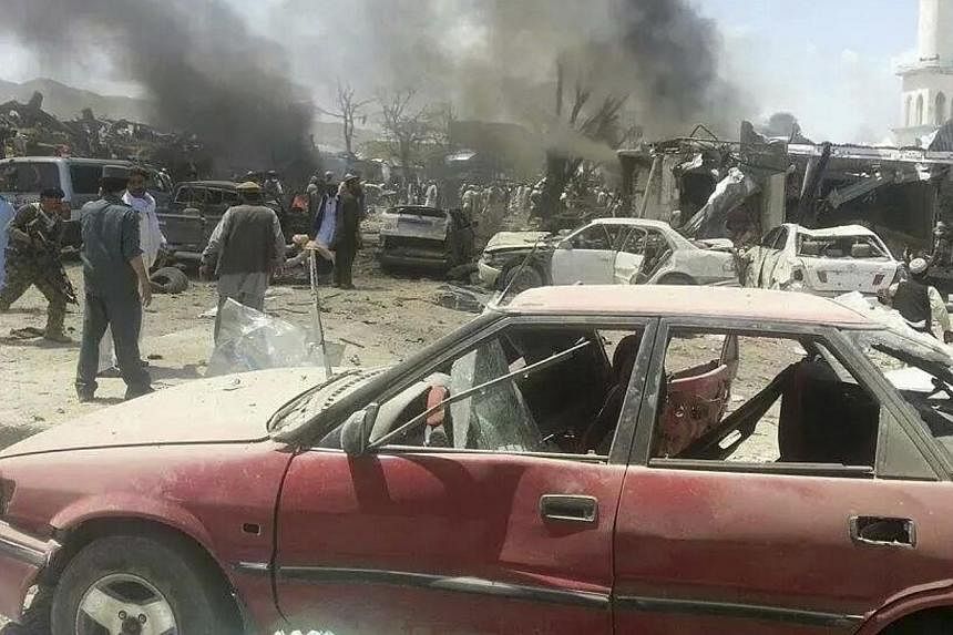 Villagers gather at the site of a car bomb attack in Urgon district, eastern province of Paktika on July 15, 2014.&nbsp;Afghan officials on Wednesday, July 16, 2014, began investigating a devastating suicide bombing at a busy market that killed at le