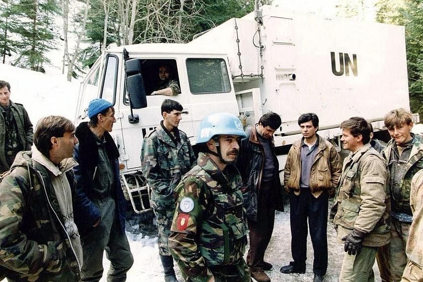 &nbsp;A file photo taken on March 1, 1994 shows Dutch soldiers of a Dutchbat convoy chatting with Bosnian Muslim fighters in Vares, Bosnia. A court in the Netherlands ruled Wednesday, July 16, 2014, that the Dutch state was liable for the deaths of o