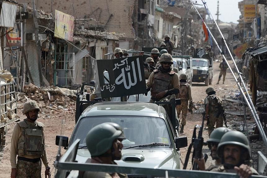 Pakistani soldiers patrol through a destroyed bazaar during a military operation against Taliban militants, in the main town of Miranshah in North Waziristan&nbsp;on July 9, 2014.&nbsp;A US drone strike hit a suspected militant compound in Pakistan's