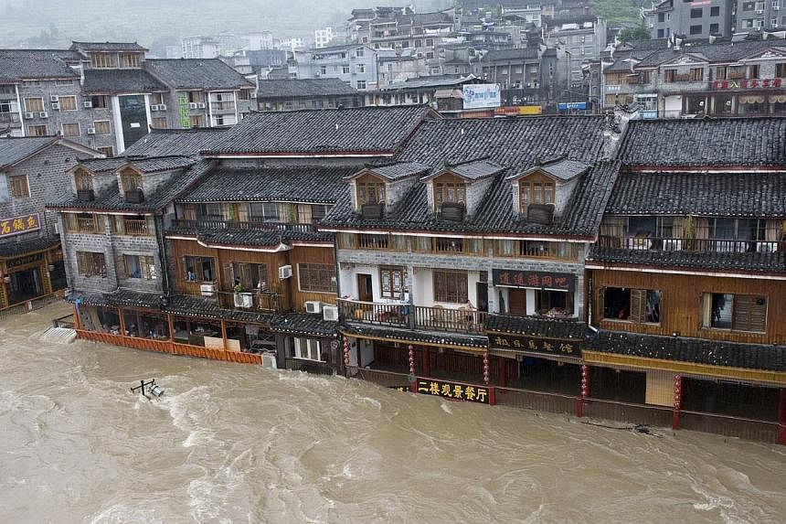 Floodwaters engulfing streets in the ancient town of Fenghuang, central China's Hunan province on July 15, 2014. -- PHOTO: AFP