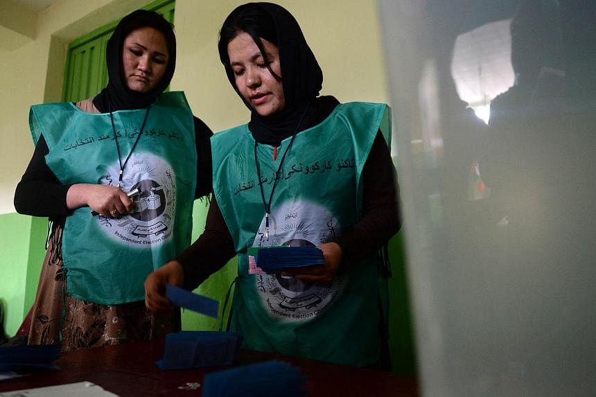 Afghan election workers count ballot papers at a polling station in Kabul on June 14, 2014.&nbsp;The Afghan election commission is set to start on Thursday an unprecedented audit of all 8.1 million votes cast in the June 14 run-off presidential elect