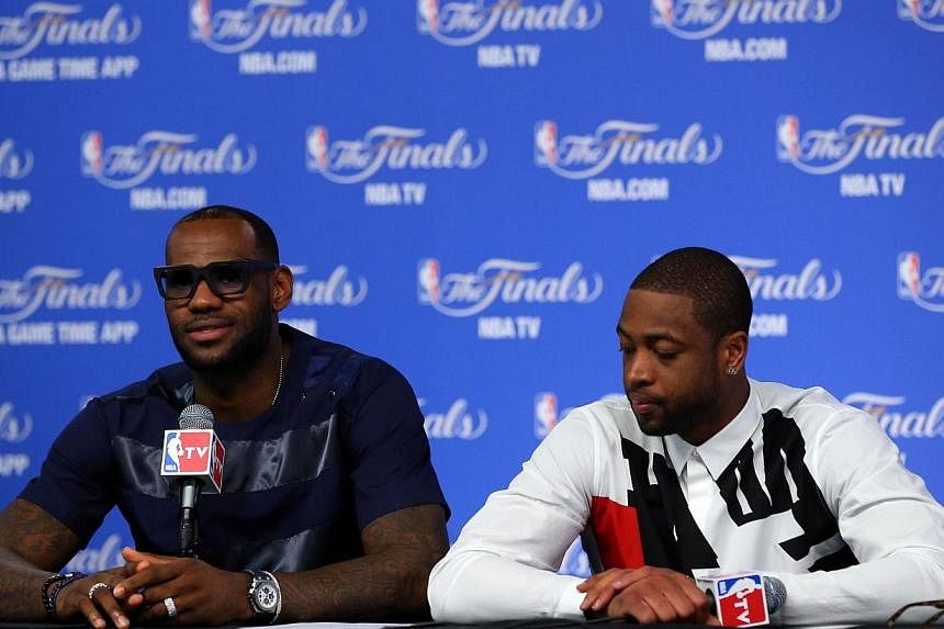 LeBron James #6 and Dwyane Wade #3 of the Miami Heat speak to the media following a 104-87 loss in Game Five of the 2014 NBA Finals at the AT&amp;T Center on June 15, 2014 in San Antonio, Texas.&nbsp;Dwyane Wade will stay with the Miami Heat to aid t