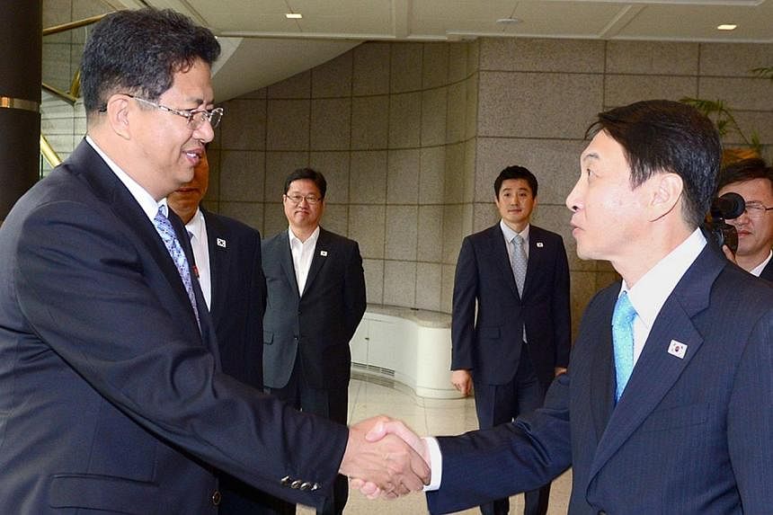 This handout picture released by South Korea's Unification Ministry shows Kwon Kyung-Sang (right), secretary general of the Incheon Asian Games Organizing Committee, greeting Son Kwang-Ho (left), vice chairman of the North Korean Olympic Committee, b