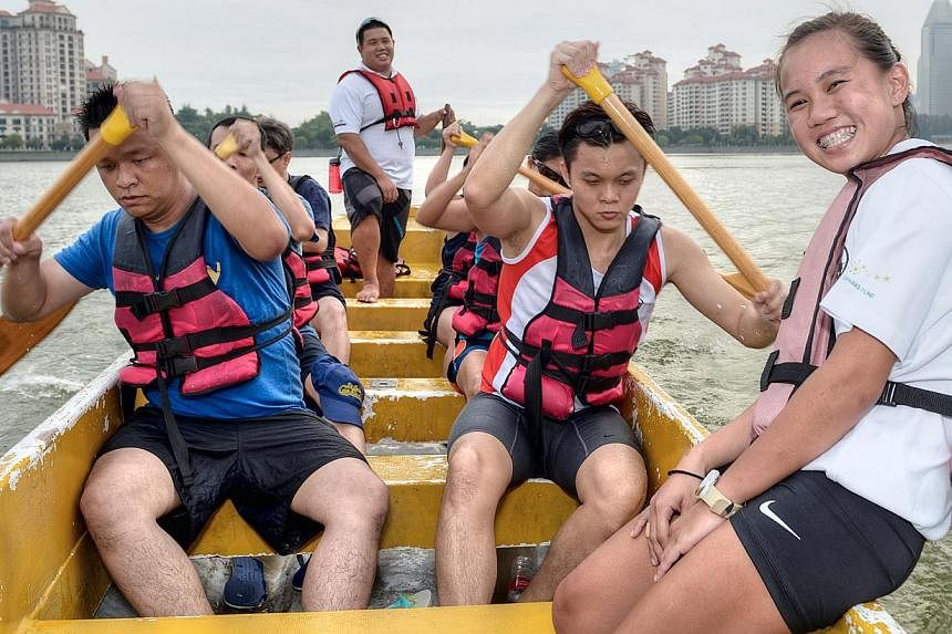 Mr Ryan Ng (standing) and Ms Debra Lam (right) with the Deaf Dragons - a dragon boat team comprising hearing-impaired members that was set up in 2012 by the duo. They are currently working on a project to establish a gym that would cater for disabled