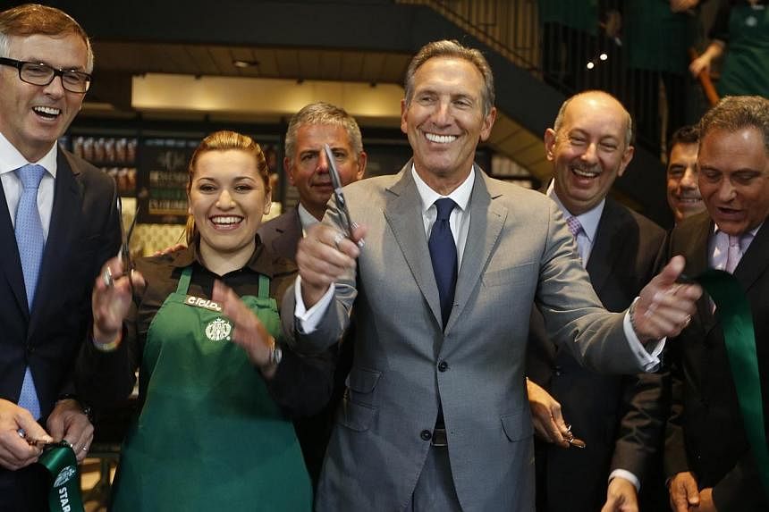 CEO of Starbucks Howard Schultz (centre) smiles after inaugurating the coffee chain's first Colombian store at 93 park in Bogota on July 16, 2014. -- PHOTO: REUTERS