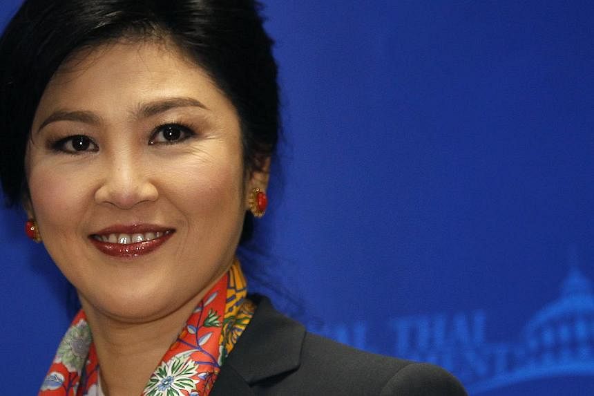 Thailand's Prime Minister Yingluck Shinawatra smiles as she arrives to address reporters in Bangkok in this May 7, 2014 file photo. Thailand's military rulers have given permission to Ms Yingluck to leave the country on a private trip on condition sh