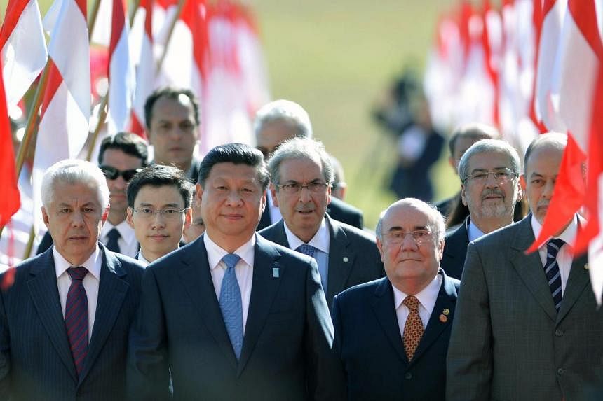 China's President Xi Jinping reviews a guard of honour upon arrival at the National Congress in Brasilia on July 16, 2014. Brazil is the first leg of a Latin American charm offensive by the Chinese leader who is also visiting Argentina, Venezuela and