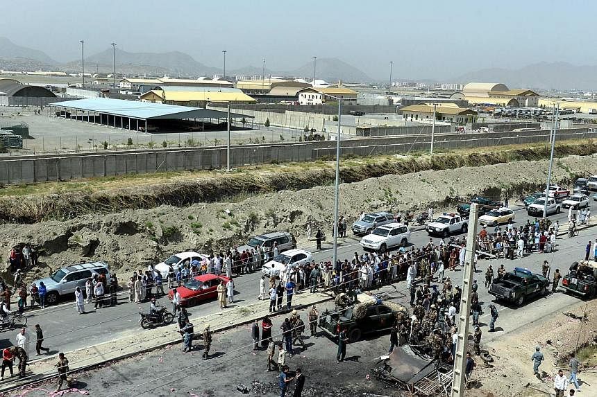 Afghan security forces and locals gather at the site of an attack by the Taliban at Kabul's airport on July 17, 2014.&nbsp;Militants armed with rocket-propelled grenades attacked Kabul International Airport in the Afghan capital on Thursday, July 17,