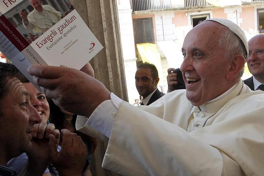 Pope Francis signs an autograph on one of his books given by a faithful, as he arrives to lead a prayer in Isernia, south of Italy,on July 5, 2014.&nbsp;An Italian director best known for telling complex on-screen love stories will begin shooting the