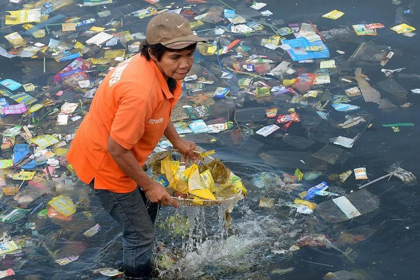 Plastic bags and other rubbish are collected from the waters of Manila Bay on July 3, 2014 during a campaign by environmental activists and volunteers calling for a ban of the use of plastic bags. -- PHOTO: AFP