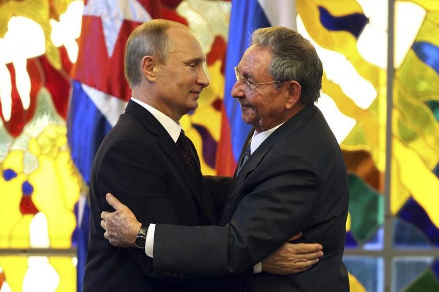 Russia's President Vladimir Putin (left) hugs Cuba's President Raul Castro after a meeting at the Revolution Palace in Havana on July 11, 2014. The visit was part of a six-day tour of Latin America for Mr Putin. -- PHOTO: REUTERS