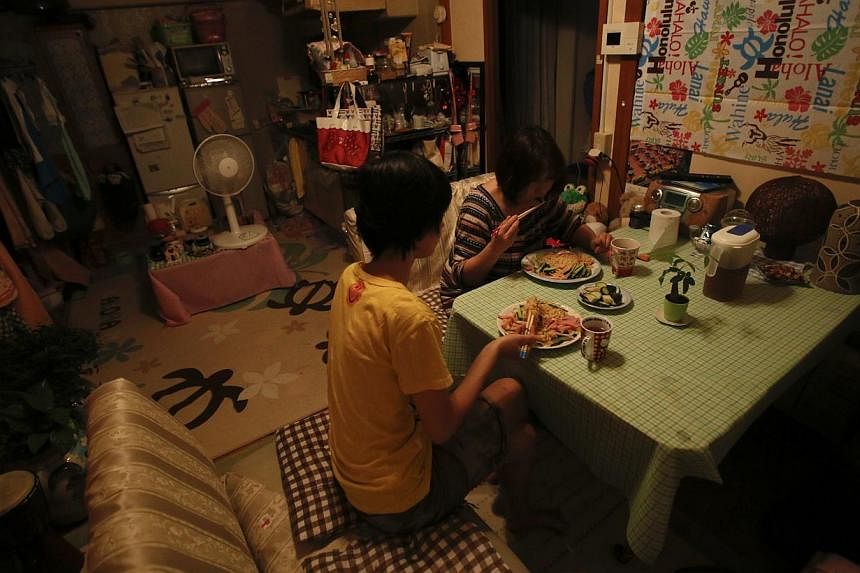 Ririko Saito and her 11-year-old daughter Yumi eat dinner together, one of only two meals they have a day in an attempt to keep household costs low, at their apartment in Tokyo on May 14, 2014. Japan's child poverty rate has hit a record high, accord