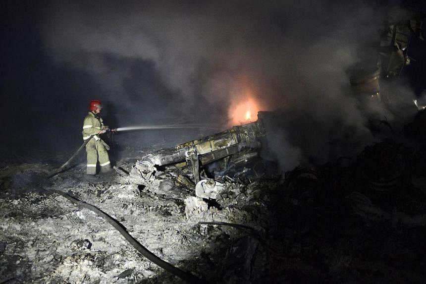 A firefighter sprays water on the wreckage of Malaysia Airlines flight MH17 carrying 298 people from Amsterdam to Kuala Lumpur after it crashed, near the town of Shaktarsk, in rebel-held east Ukraine. Wan Amran Wan Hussin, 50, the pilot of the Malays