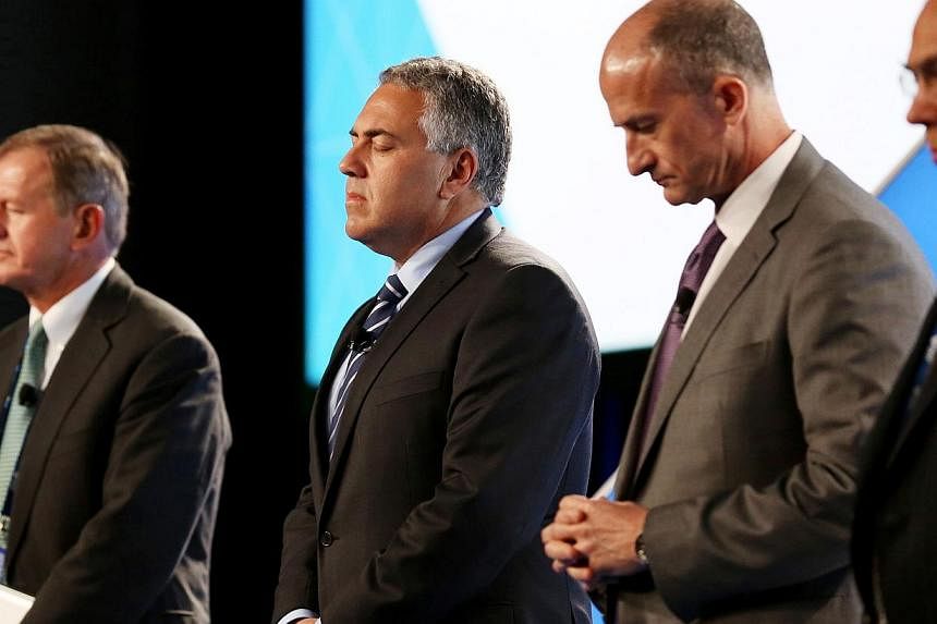 (From left) SEB Chairman Marcus Wallenberg, Treasurer of Australia Joe Hockey, GE Global Growth and Operations CEO John Rice and OECD Secretary-General Angel Gurria observe a minute of silence for the victims of Malaysia Airlines flight MH17 at the B