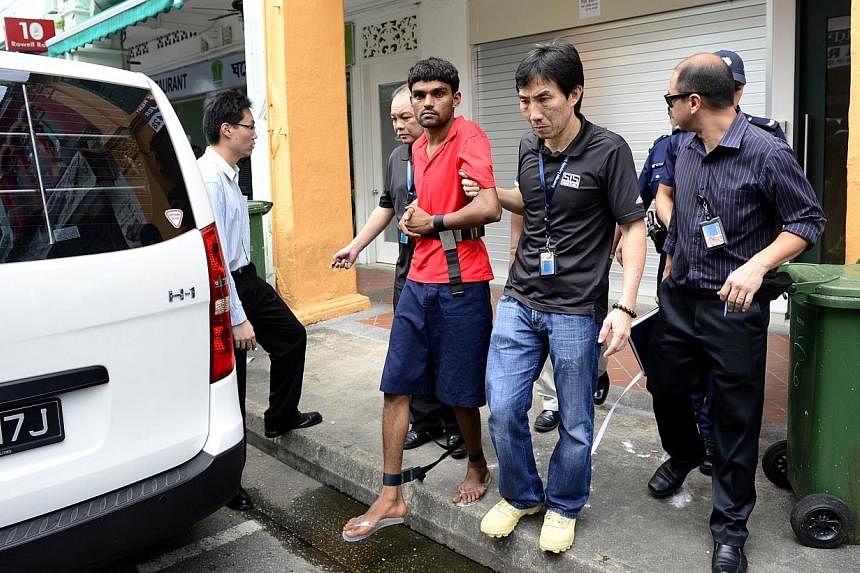 Murder suspect Ramzan Rizwan (in red) being escorted by investigators, outside the lodging house at 6 Rowell Road on June 19, 2014.&nbsp;The second Pakistan national who allegedly murdered a compatriot whose legless body was found in a suitcase has b