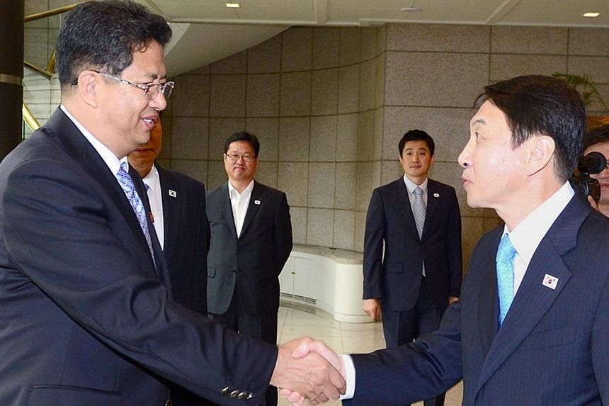 A picture released by South Korea's Unification Ministry shows Kwon Kyung Sang (right), secretary general of the Incheon Asian Games Organising Committee, greeting Son Kwang Ho (left), vice-chairman of the North Korean Olympic Committee, before their