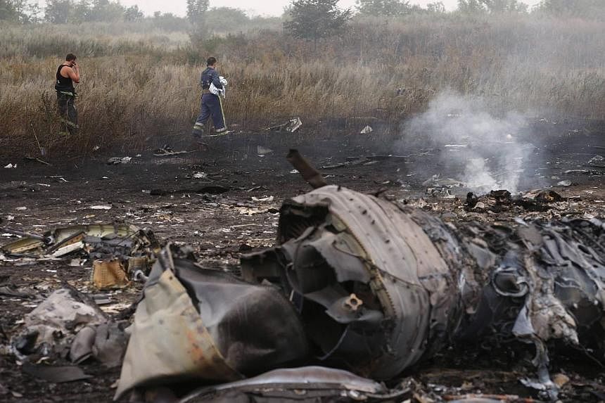 Emergencies ministry members walk at the site of a Malaysia Airlines Boeing 777 plane crash near the settlement of Grabovo in the Donetsk region, July 17, 2014. -- PHOTO: REUTERS