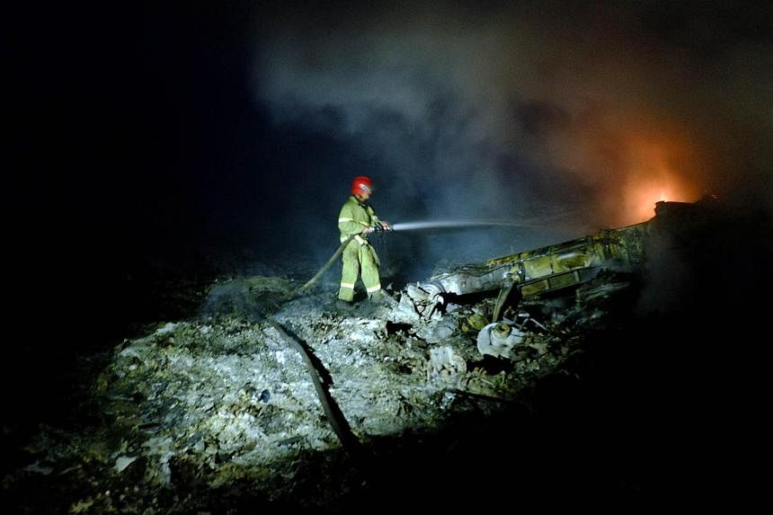 A firefighter sprays water to extinguish a fire, on July 17, 2014 amongst the wreckage of the Malaysian airliner carrying 298 people from Amsterdam to Kuala Lumpur after it crashed, near the town of Shaktarsk, in rebel-held east Ukraine. -- PHOTO: AF