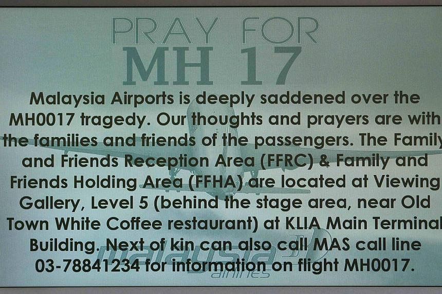 A "Pray for MH17" message is displayed on a flight information board at Kuala Lumpur International Airport in Sepang on July 18, 2014.&nbsp;The three Filipinos on board the Malaysia Airlines flight MH17 which was shot down over eastern Ukraine were a
