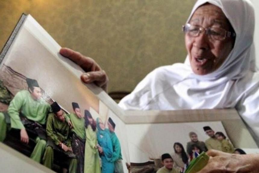 Jamillah showing the family photo album at her home. -- PHOTO: THE STAR/ASIA NEWS NETWORK