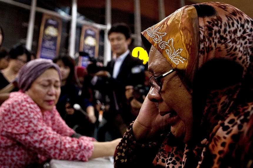 Relatives of people onboard Malaysia Airlines flight MH17 from Amsterdam react outside the family holding area at the Kuala Lumpur International Airport in Sepang on July 18, 2014. -- PHOTO: AFP