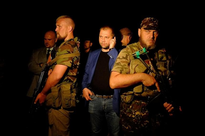 Self-proclaimed Prime Minister of the pro-Russian separatist "Donetsk People's Republic" Alexander Borodai (centre) stands as he arrives on the site of the crash of a malaysian airliner carrying 298 people from Amsterdam to Kuala Lumpur, near the tow
