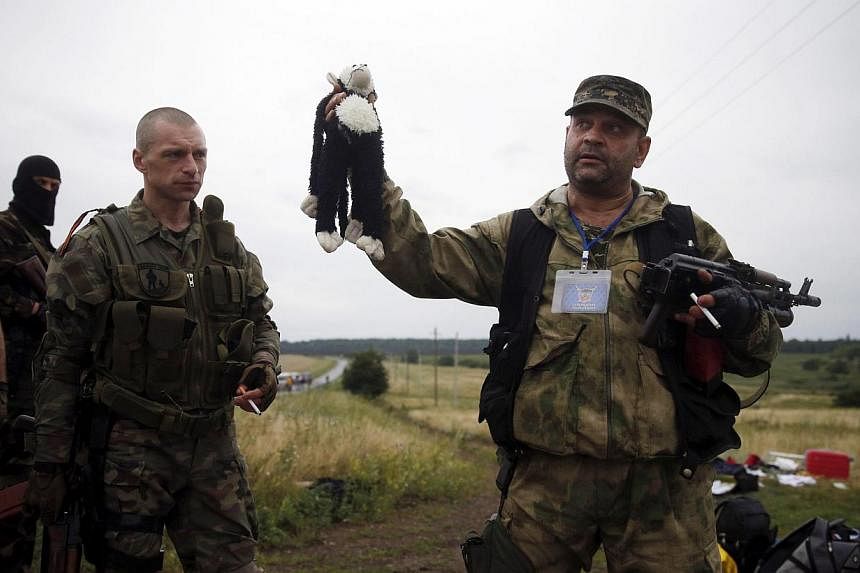 A pro-Russian separatist holds a stuffed toy found at the crash site of Malaysia Airlines flight MH17. United States President Barack Obama demanded Russia stop supporting the separatists in Ukraine after the downing of the airliner by a surface-to-a