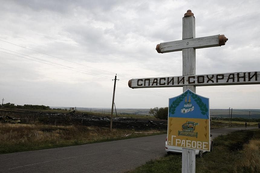 The village sign of Grabovo is seen near debris at the site of Thursday's Malaysia Airlines Boeing 777 plane crash, near Grabovo in the Donetsk region on July 18, 2014. -- PHOTO: REUTERS