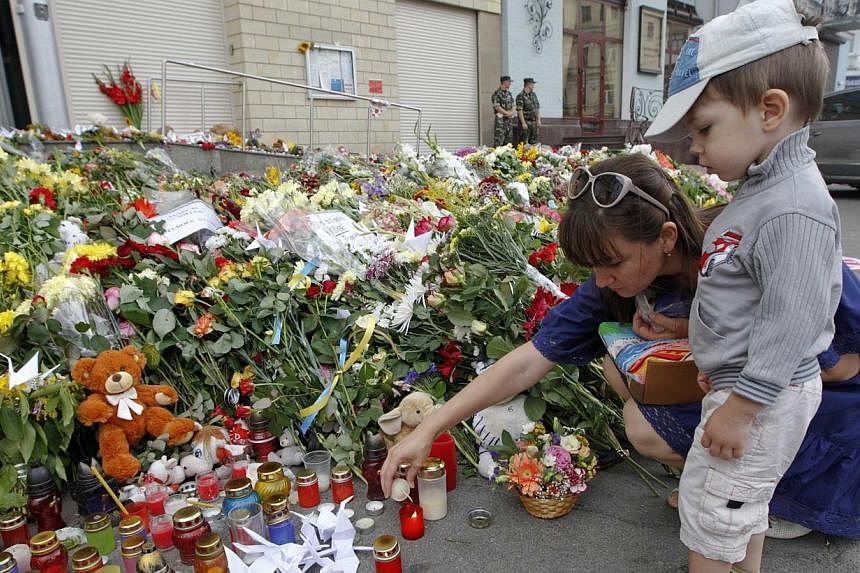 Local residents light a candle for victims of Malaysia Airlines Flight MH17, outside the Dutch embassy in Kiev ON July 19, 2014.&nbsp;Britain on Saturday, July 19, 2014, said Russia was not exerting its influence over pro-Moscow separatists in easter